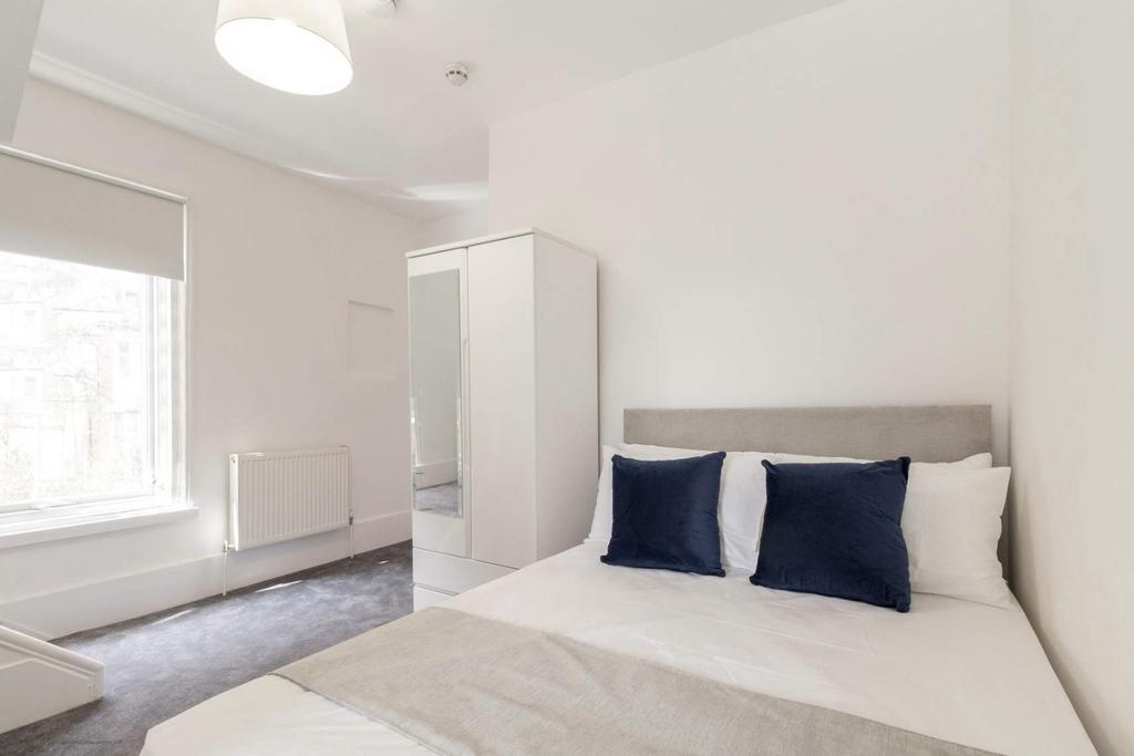 Bright, tidy bedroom with modern bed and wardro...