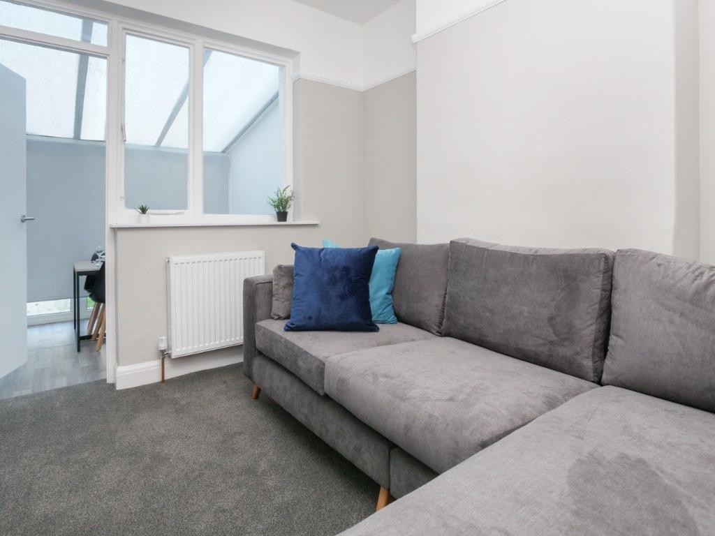 Bright living area with modern grey sofa...