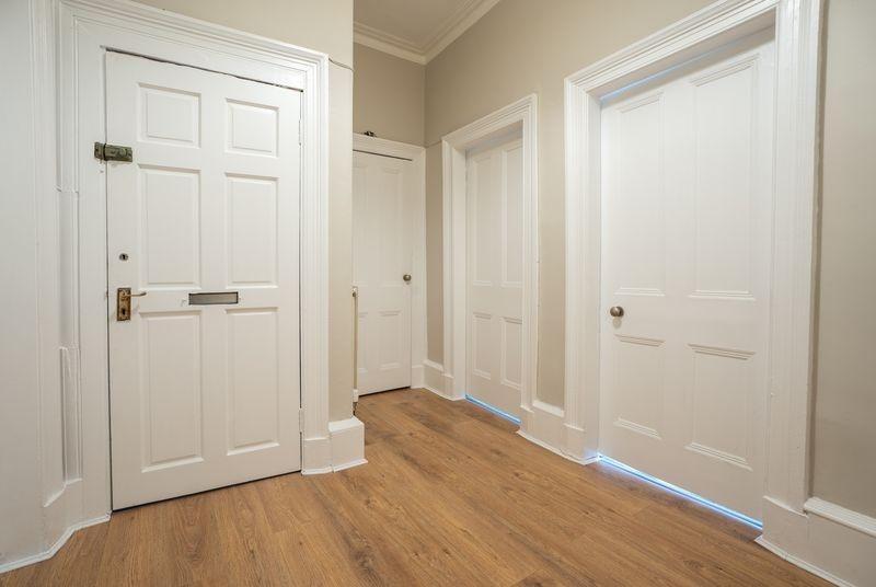 Bright, modern hallway with wood flooring...