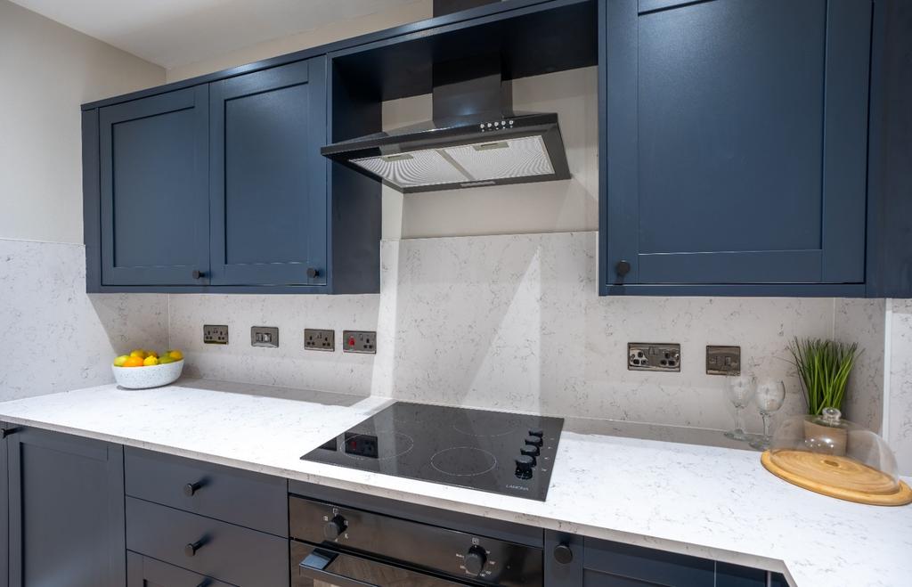 Modern kitchen with navy cabinets and white wor...