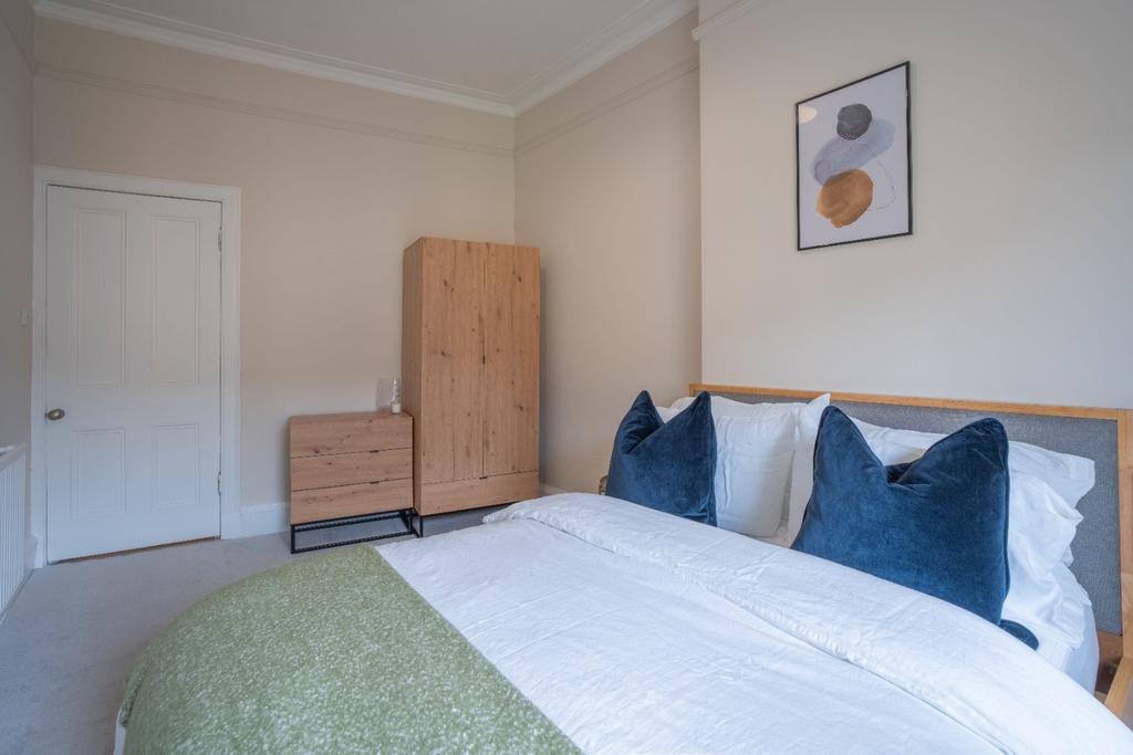 Bright, neatly styled bedroom with double bed...