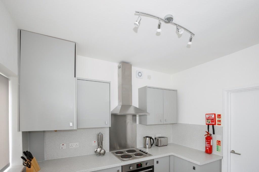Modern white kitchen with stainless appliances...