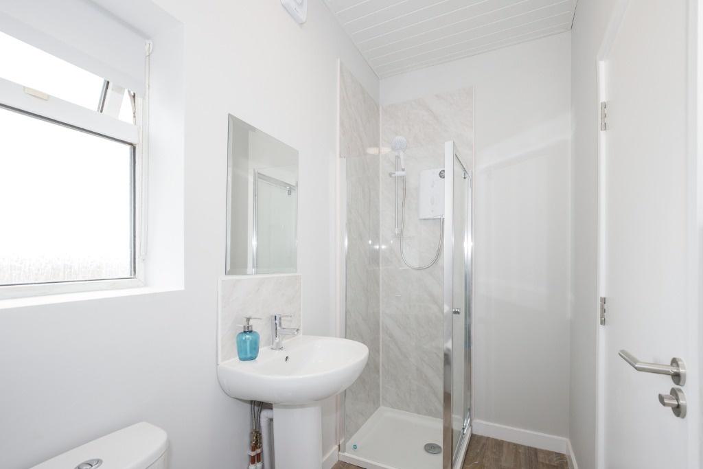 Bright modern bathroom with walk-in shower...