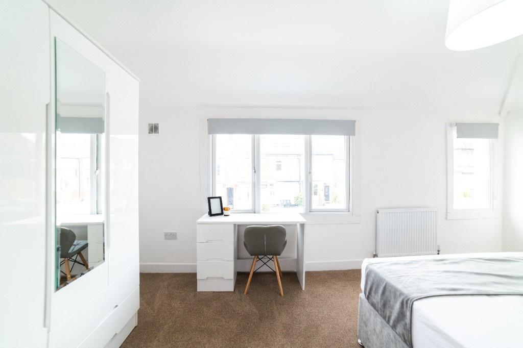 Bright modern bedroom with desk and storage...