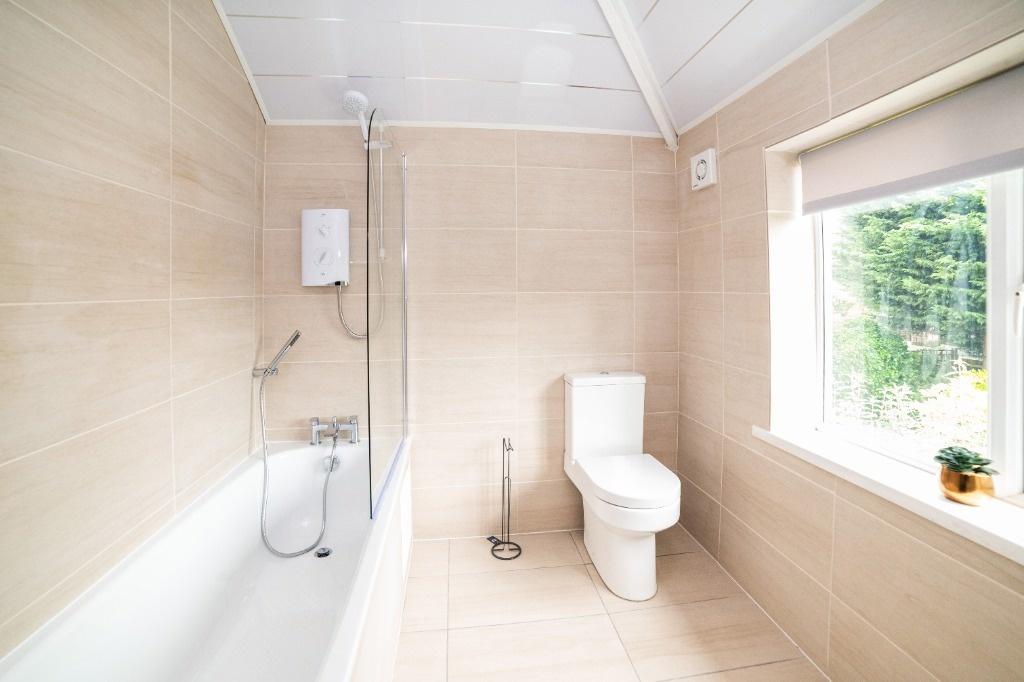 Bright modern bathroom with bath and window...
