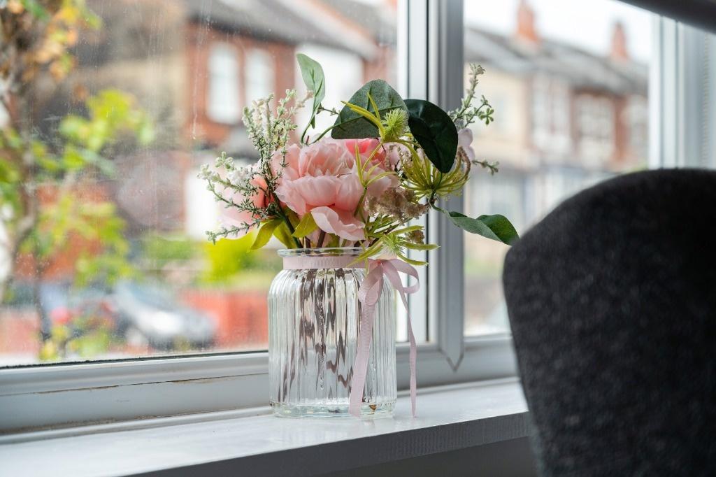 Bright window with stylish vase and city view...