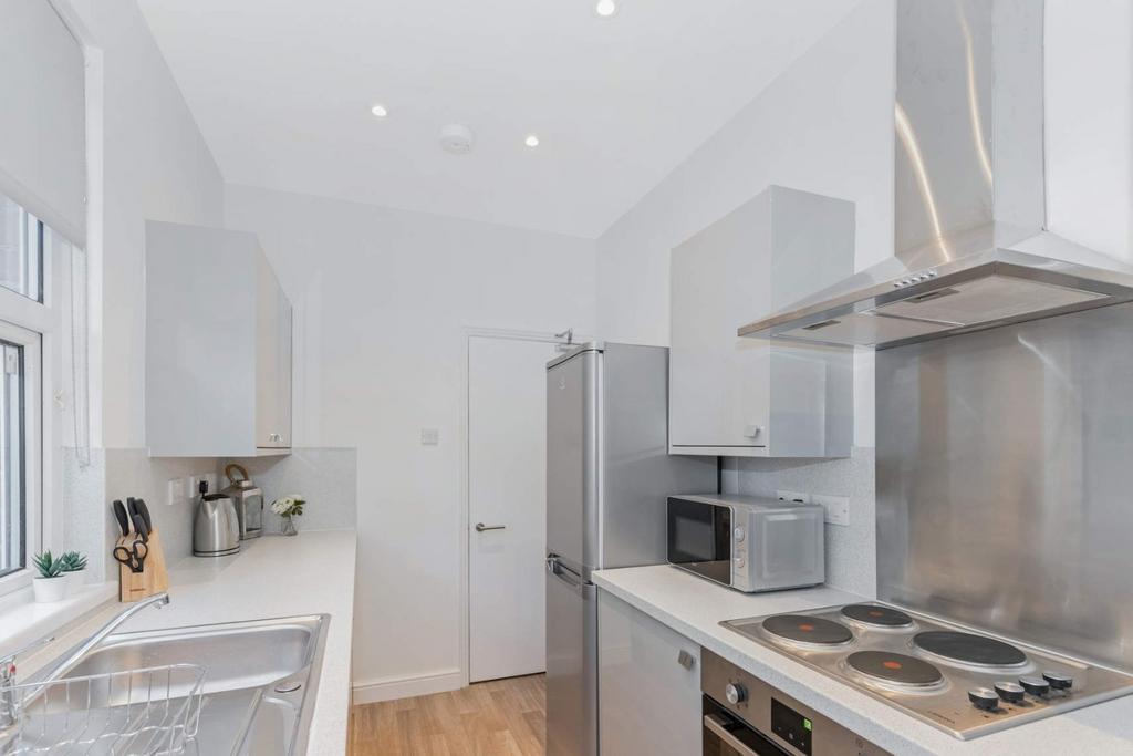 Bright modern kitchen with integrated appliance...