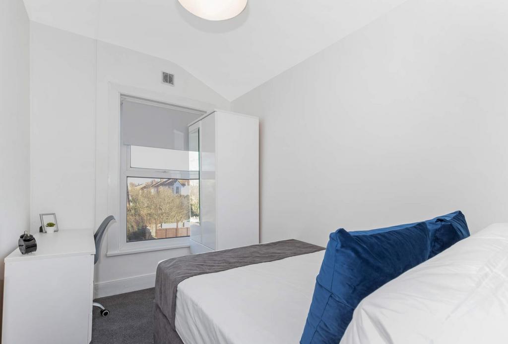 Bright, neatly furnished bedroom with study are...