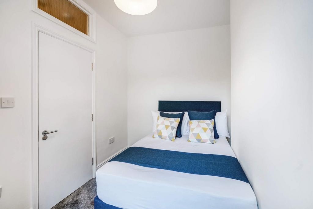 Bright, neatly staged double bed with modern de...