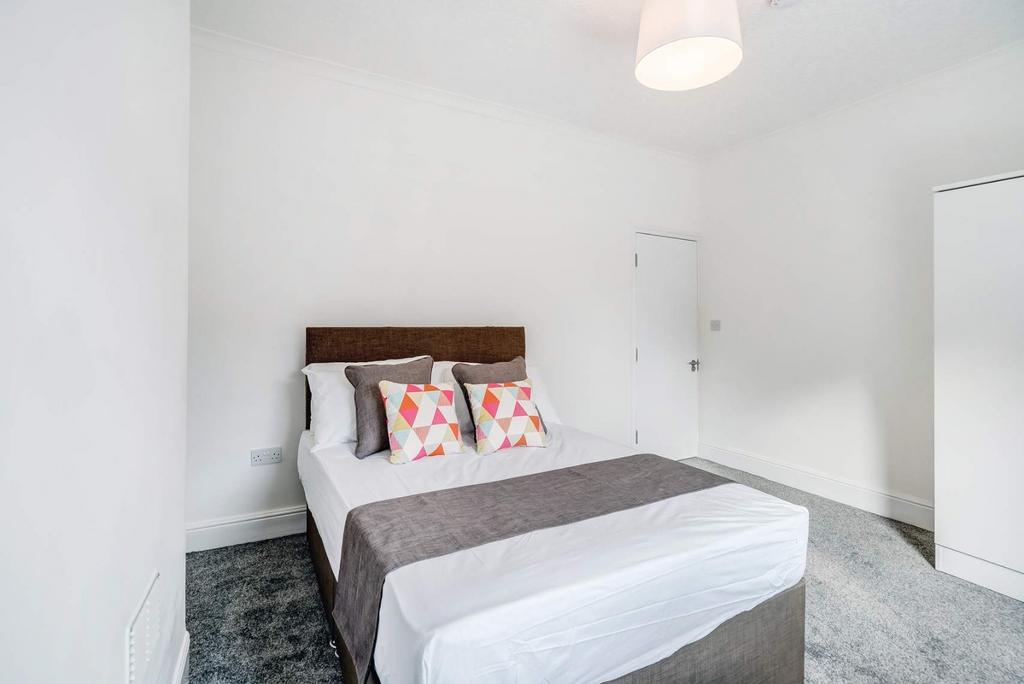 Bright double room with neat bed and neutral de...