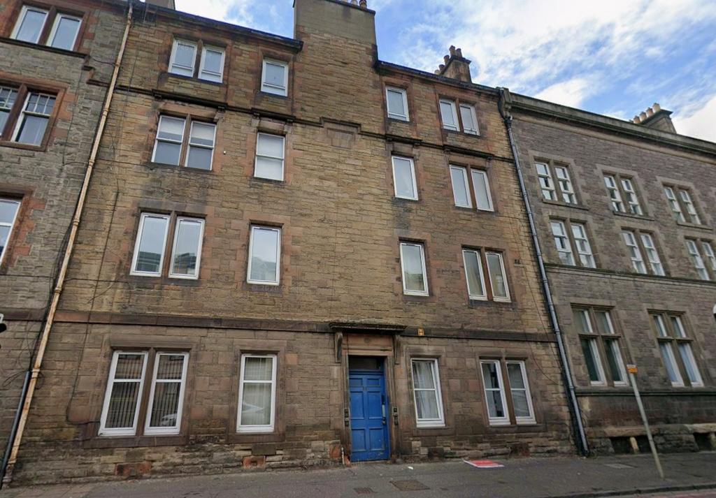 Stone-fronted building with bright blue entranc...