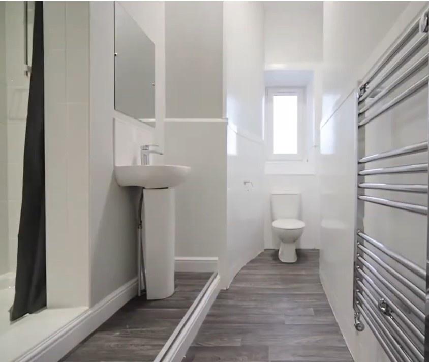 Bright modern bathroom with shower and towel ra...