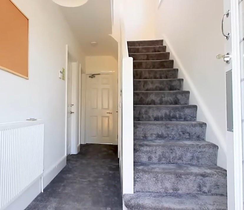Bright modern hallway with carpeted stairs...