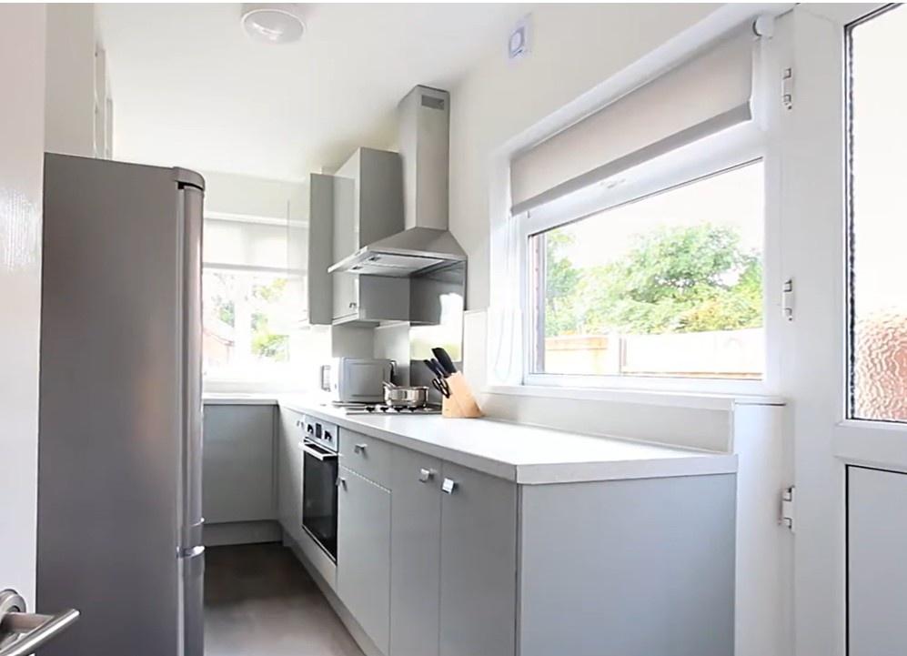 Bright modern galley kitchen with white worktop...