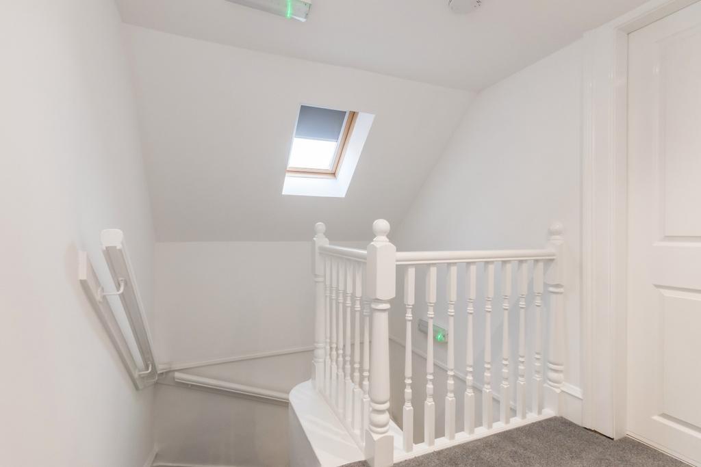 Bright landing with skylight and white balustra...