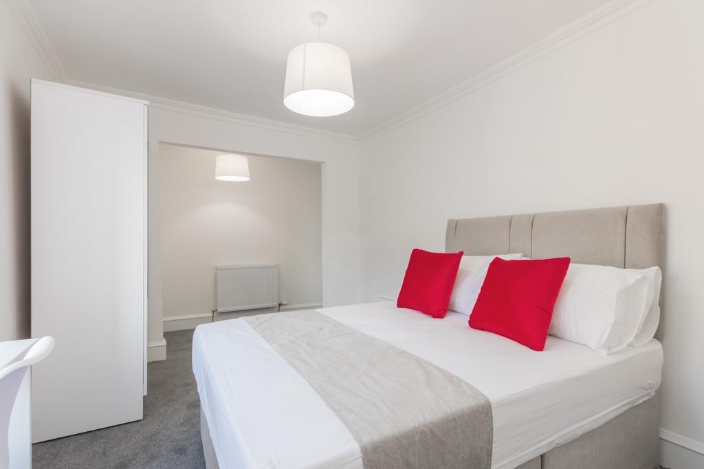 Bright bedroom with neutral decor and bold acce...