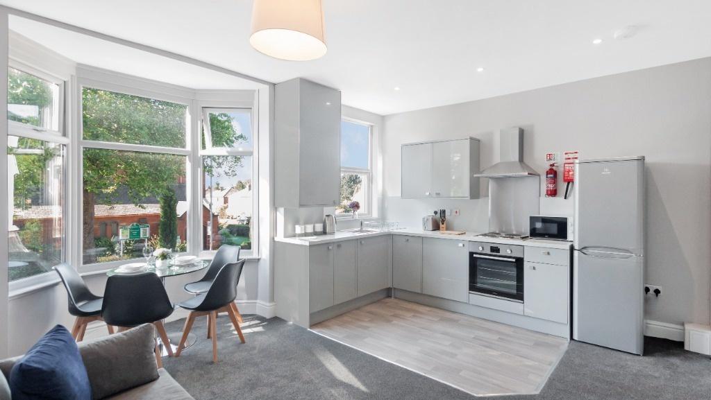 Bright bay-window living area with modern kitch...