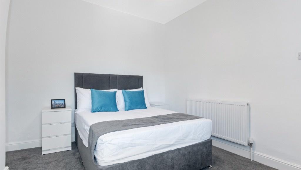 Bright, modern bedroom with double bed and stor...