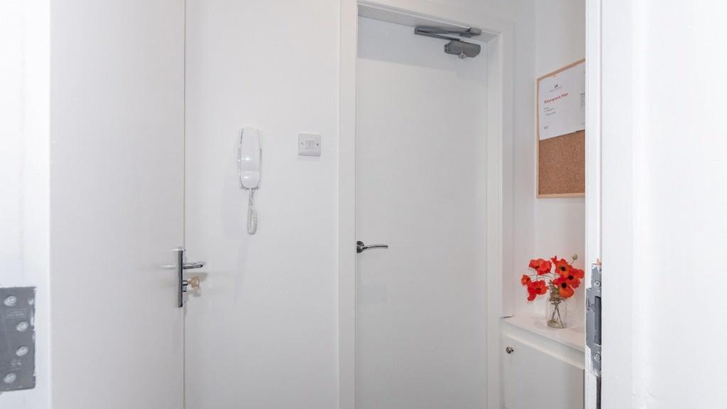 Bright, tidy white hallway with decorative touc...