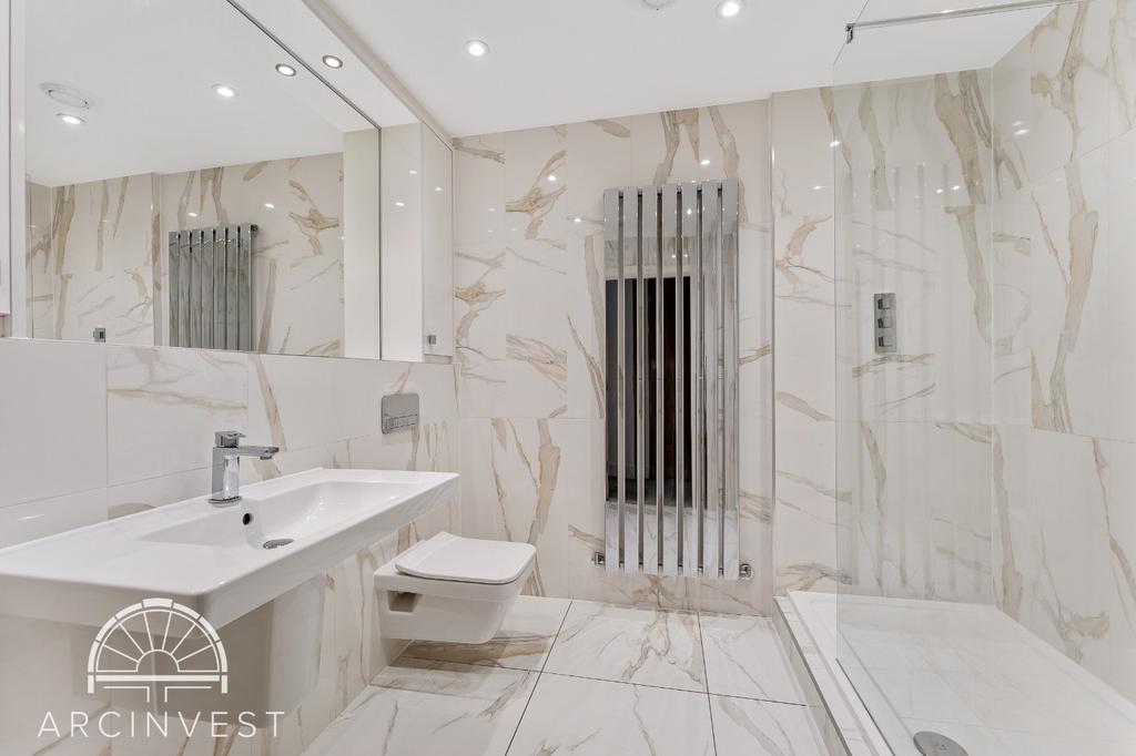 Bright modern marble bathroom with heated towel...