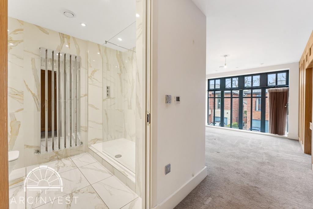 Bright en‑suite bedroom with large windows...