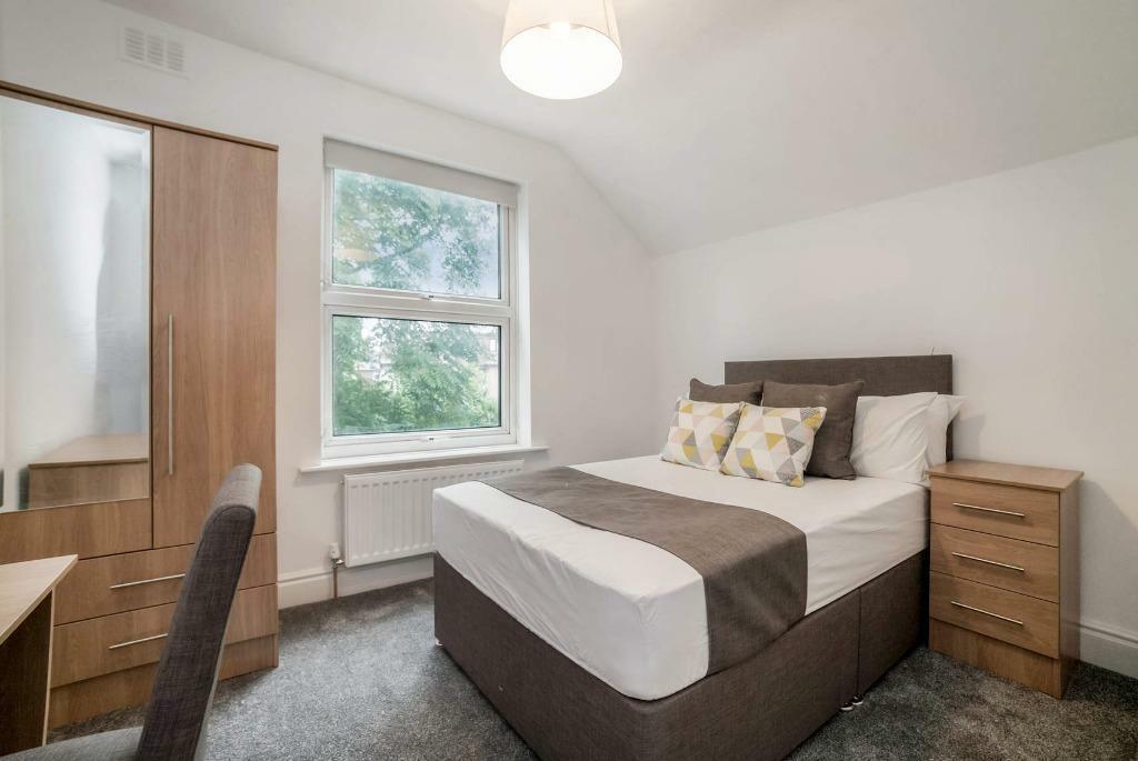 Bright, neatly styled double bedroom with stora...