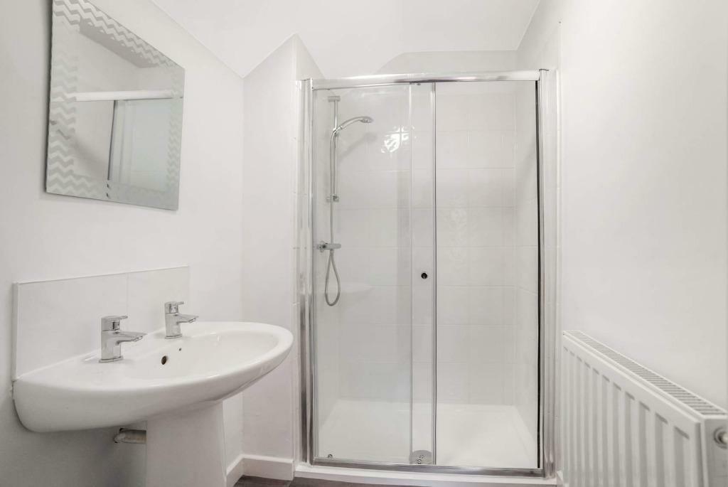 Fresh white bathroom with modern corner shower...