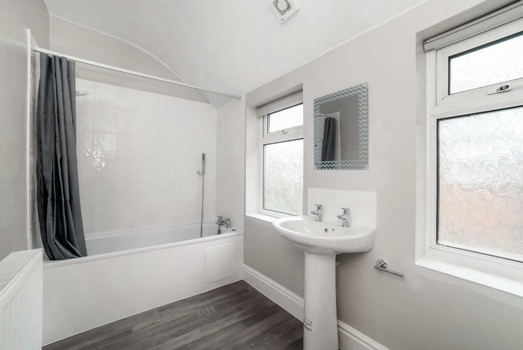 Bright modern bathroom with bath and shower...