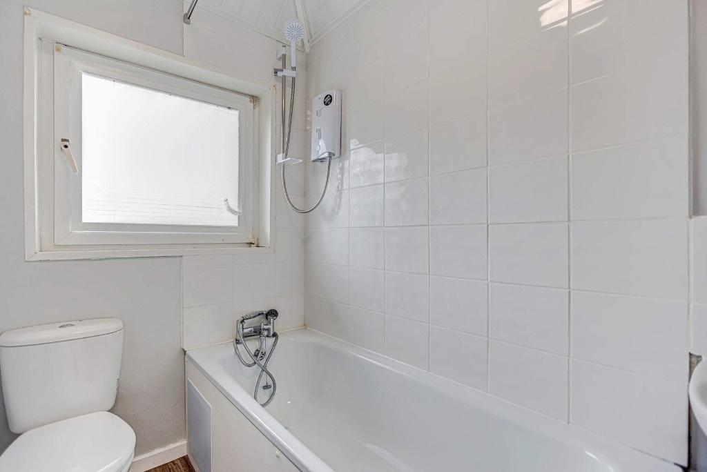 Bright bathroom with tub and shower...