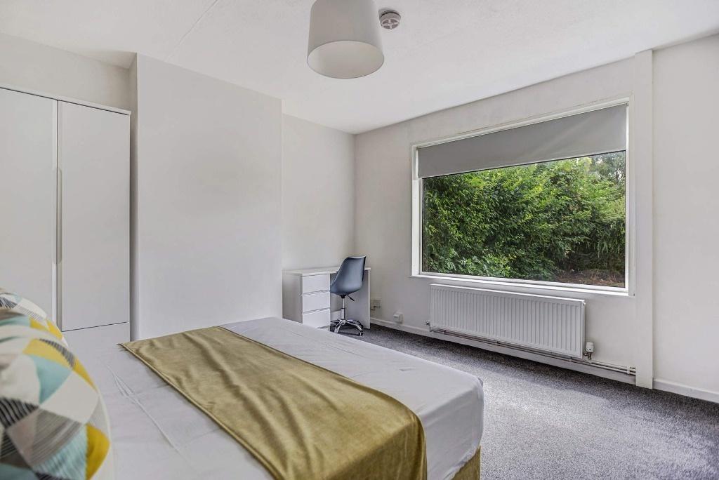Bright bedroom with large window and wardrobe...