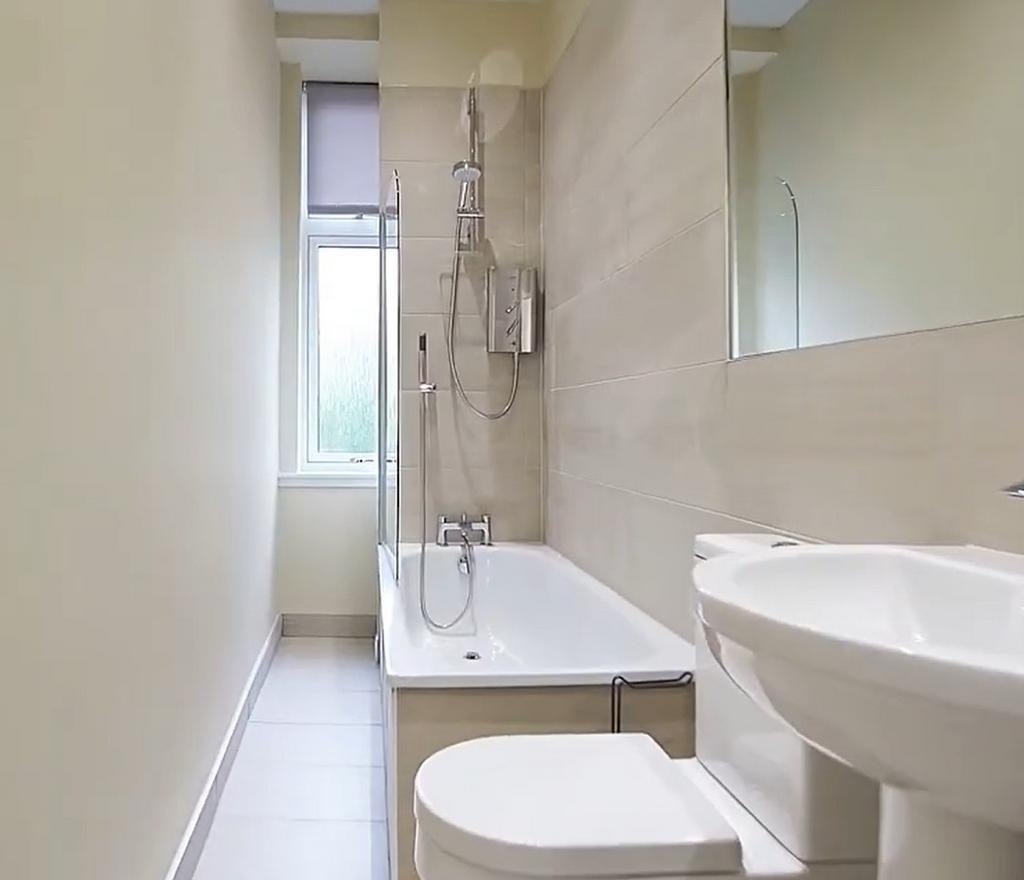 Bright modern bathroom with shower-over-bath...