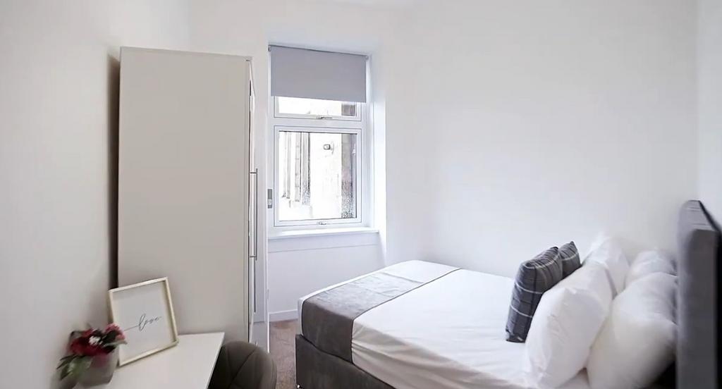 Bright, neatly furnished bedroom with double be...