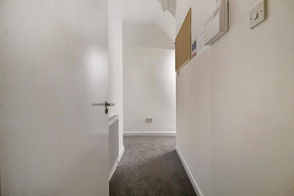 Bright neutral hallway with carpeting...