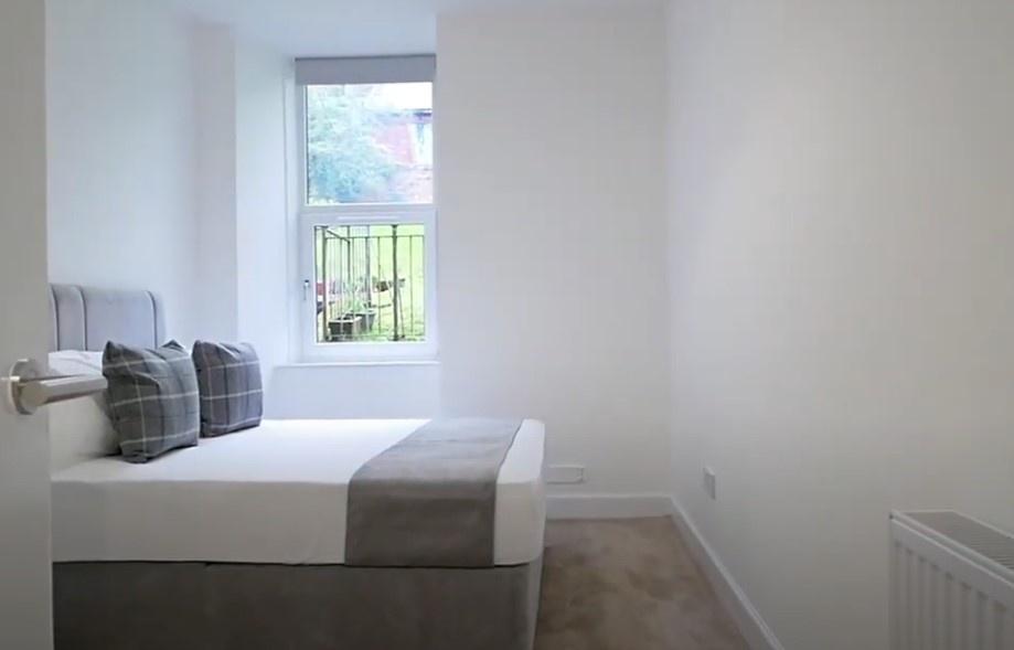 Bright, simple bedroom with neat bedding...