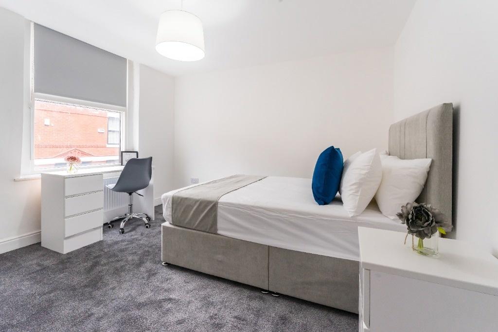 Bright, modern double bedroom with desk and bed...