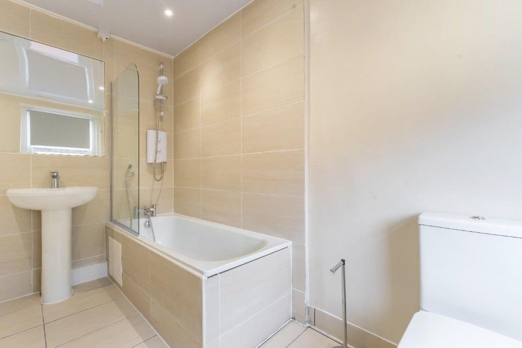 Bright modern bathroom with tub and clean tiles...