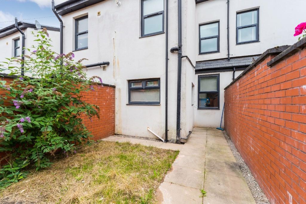 Private paved yard with lawn and rear access...