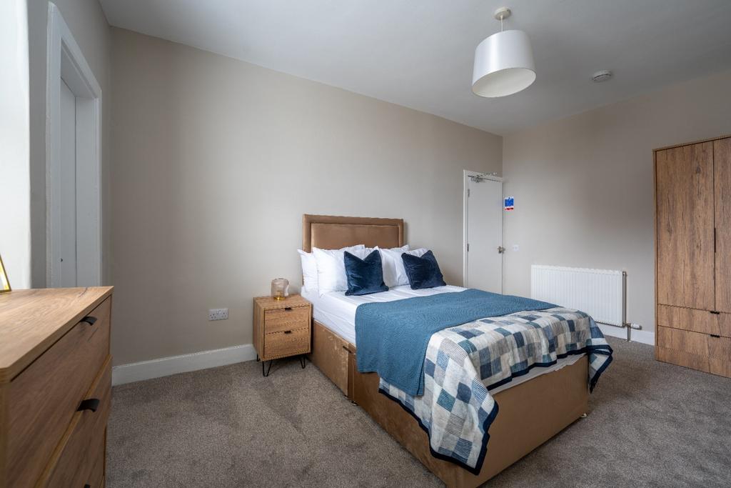 Bright, tidy bedroom with wooden furniture...