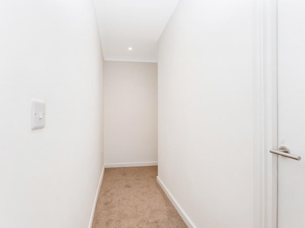 Bright, clean narrow hallway with neutral decor...