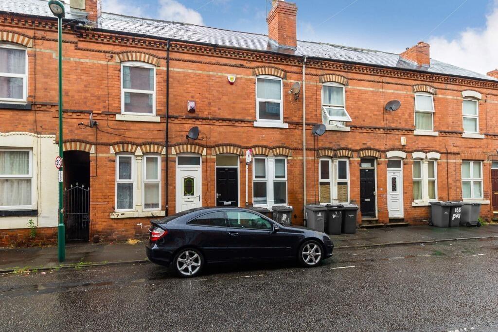 Terraced brick house with on-street parking and...