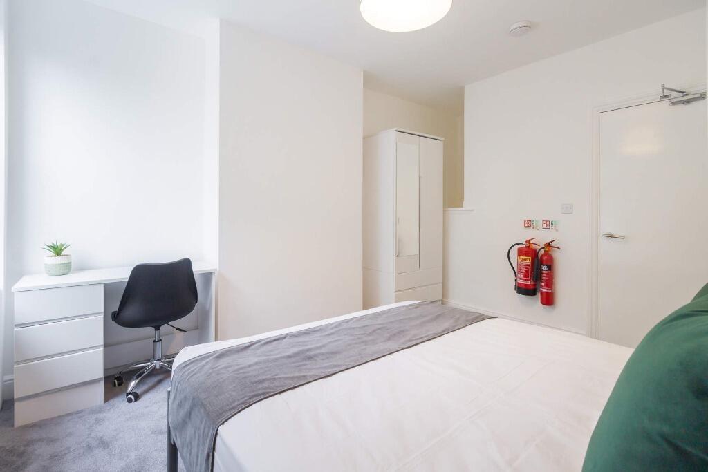 Bright, tidy bedroom with desk and storage...