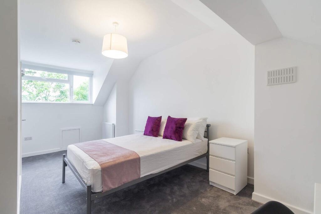Bright bedroom with neat bed and modern decor...