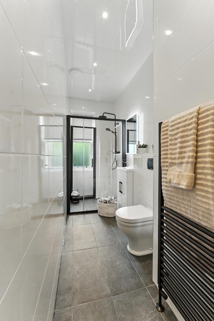 Modern bathroom with walk-in shower and sleek t...