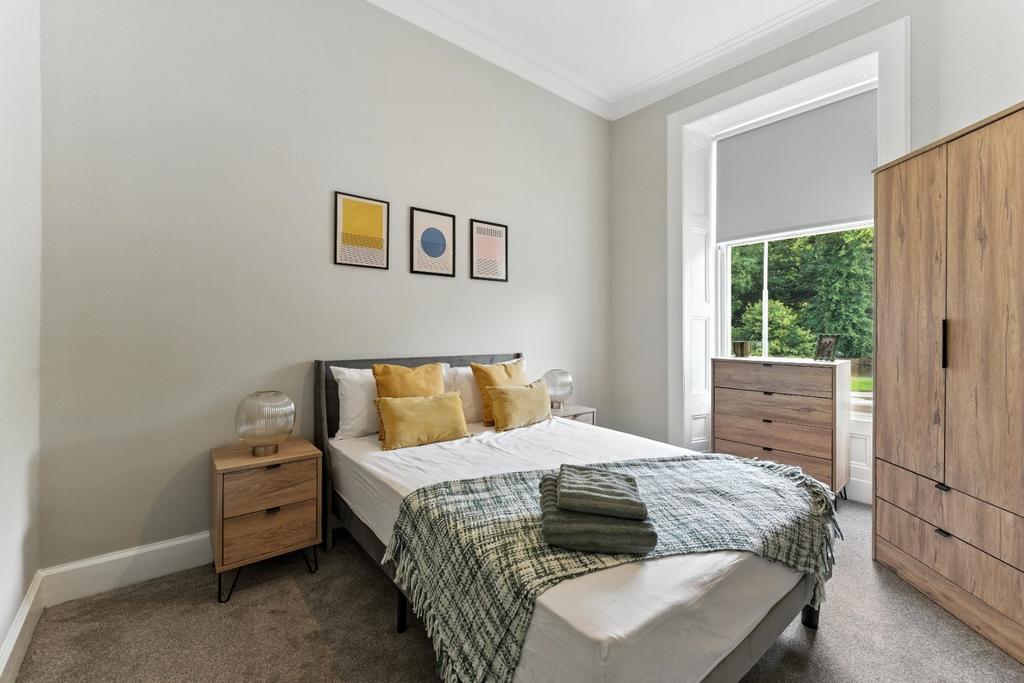 Bright, neatly furnished bedroom with wardrobe...