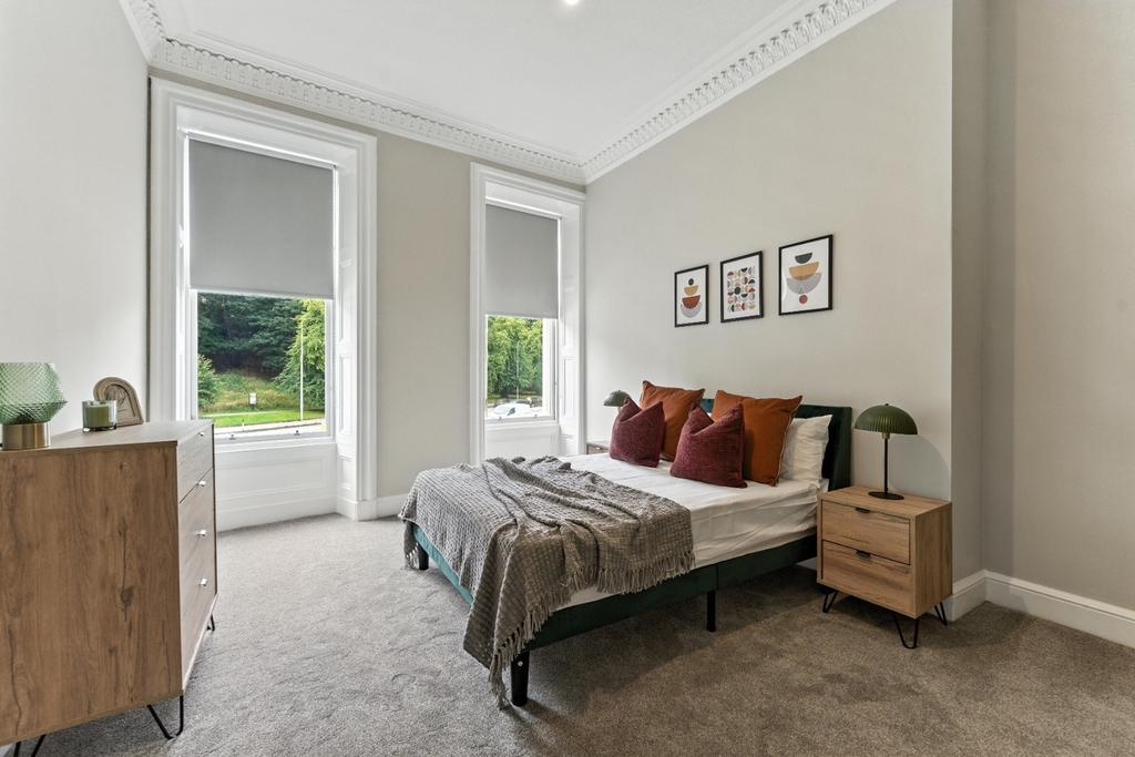 Bright bedroom with high ceilings and modern dé...