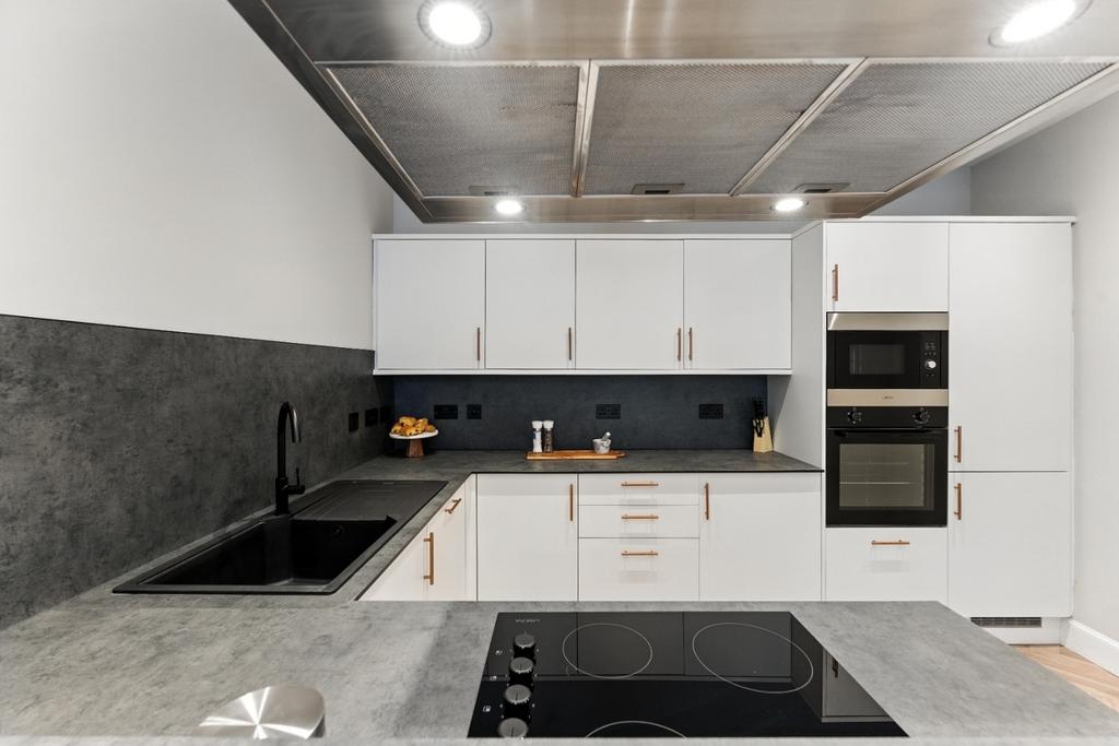 Modern white kitchen with integrated appliances...