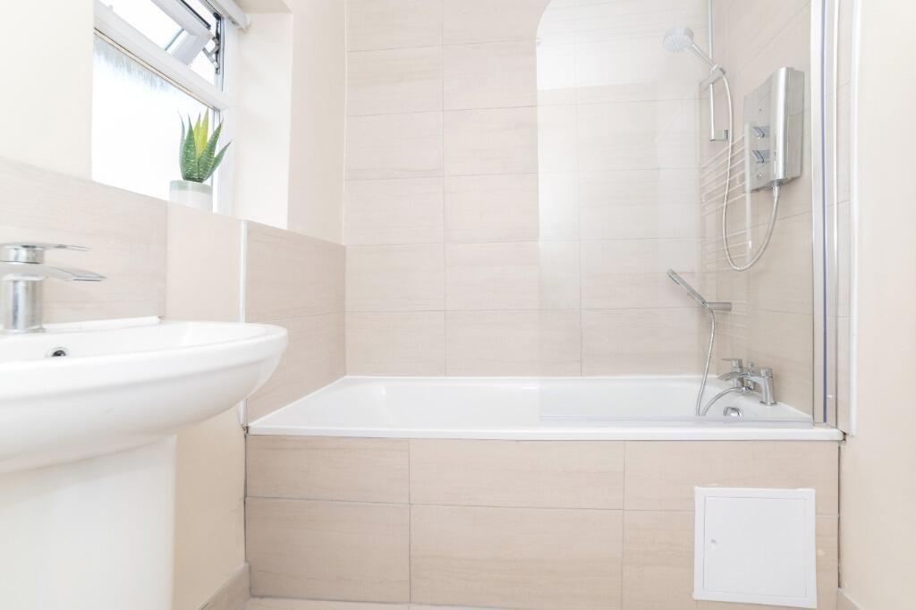 Bright, modern bathroom with bath and shower...