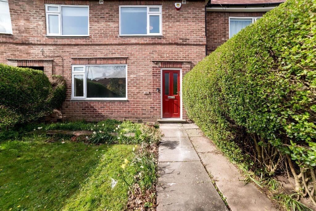Red-fronted terraced home with neat front garde...