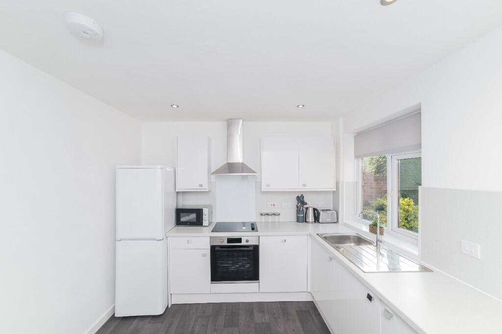Bright modern kitchen with white units...