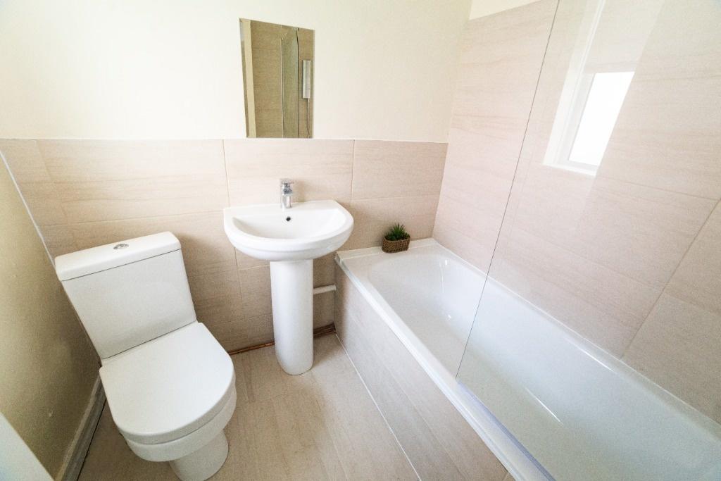 Bright, clean modern bathroom with white fittin...